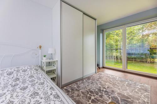 Un dormitorio con una cama y una ventana grande en Seaside apartments - Sunset apartment, en Klaipėda