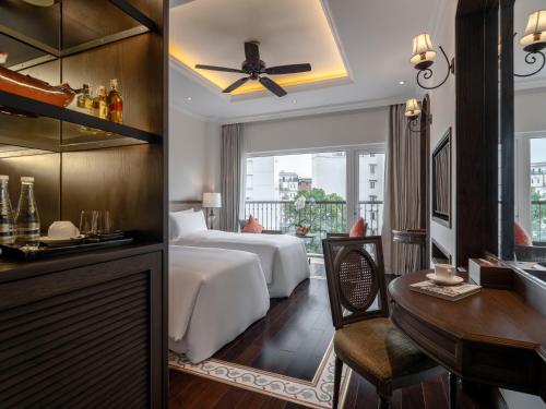 a hotel room with a bed and a desk at De Syloia Hotel in Hanoi