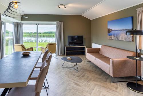 a living room with a couch and a table at Recreatiepark De Bosrand in Oudemirdum
