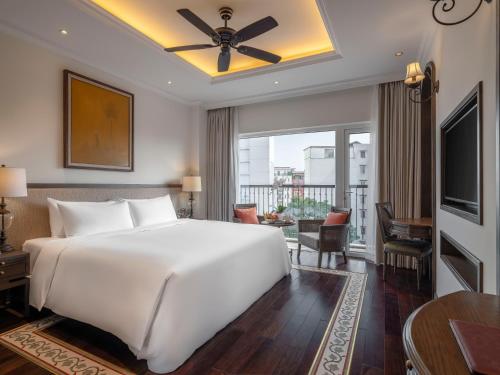 a bedroom with a large white bed and a balcony at De Syloia Hotel in Hanoi