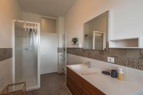 a bathroom with a sink and a shower with a mirror at Casa Primo Maggio in Cerasolo
