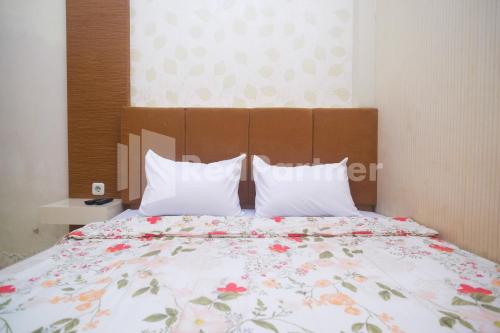 ein Schlafzimmer mit einem großen Bett mit einer Blumenbettdecke in der Unterkunft Tatti Inn Syariah Seturan RedPartner in Yogyakarta