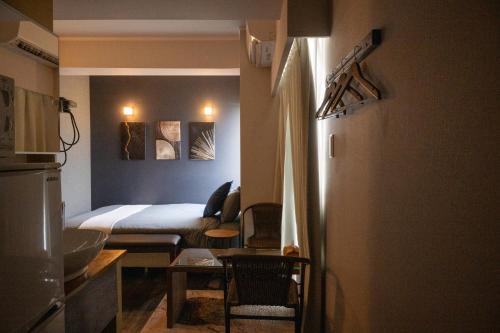 a small room with a bed and a table at Hotel SERA LUNA -ホテル セラルナ- in Naha