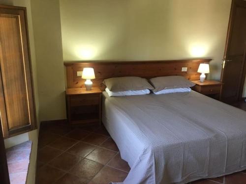 - une chambre avec un grand lit et deux lampes de chaque côté dans l'établissement Cozy home in countryside Asciano Siena -renovated!, à Asciano