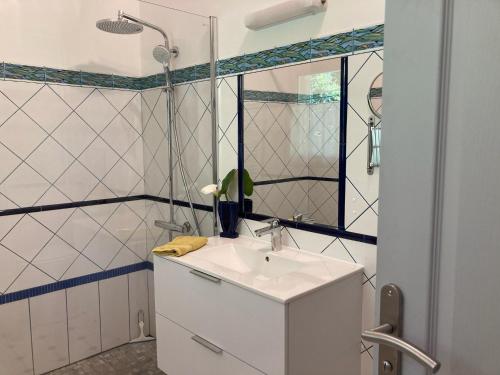 a bathroom with a sink and a shower at Douceur des Pins in Saint-Trojan-les-Bains