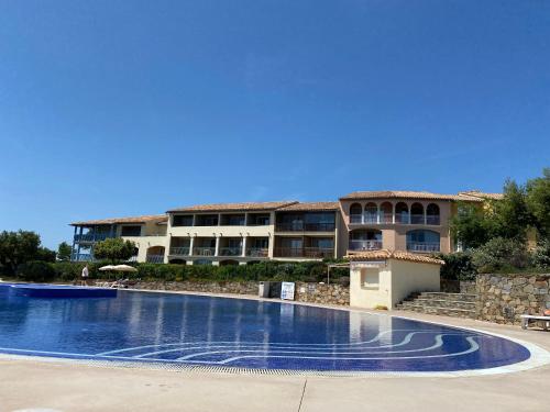 une grande piscine devant un immeuble dans l'établissement Atricadix, à La Garonnette-Plage
