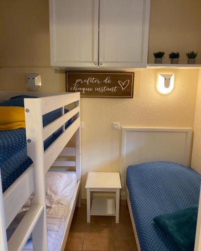 une petite chambre avec deux lits superposés et un panneau dans l'établissement Atricadix, à La Garonnette-Plage