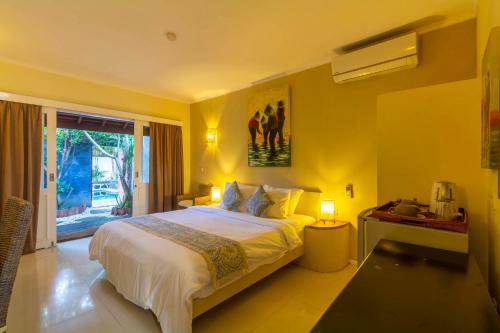 a bedroom with a large bed with yellow walls at Scallywags Mango in Gili Air