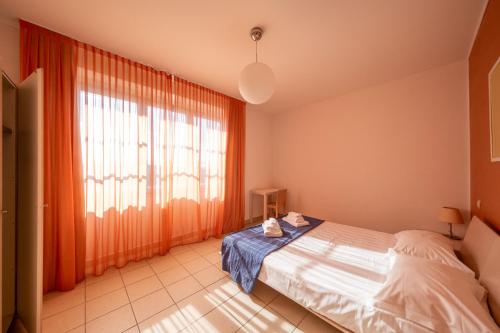 um quarto com uma cama e uma grande janela em Solidago Residence em Tirrenia
