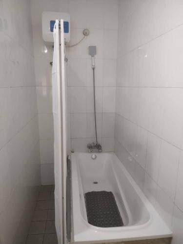 a white bathroom with a bath tub with a drain at TRENDY INN HOTEL in Lagos