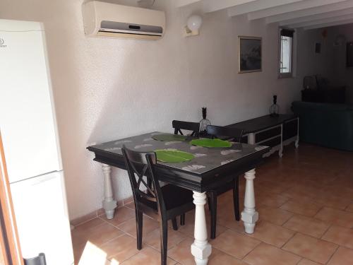 - une table avec des assiettes vertes dans le salon dans l'établissement Grand studio au milieu des vignes, à Moussan