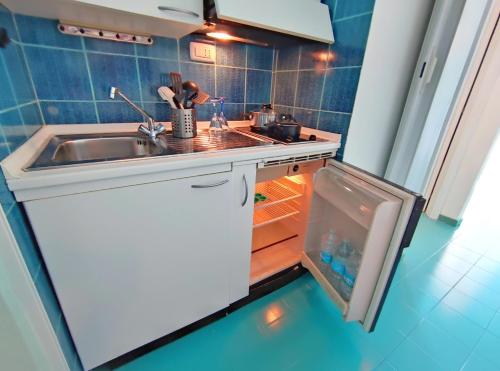 una cucina con lavandino e frigorifero aperto di PADA VESPUCCI a Rimini