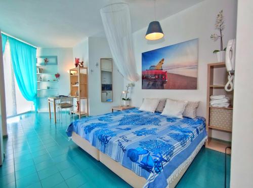 una camera da letto blu e bianca con un letto e un tavolo di PADA VESPUCCI a Rimini