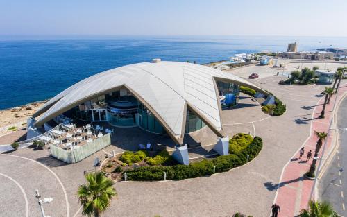 an overhead view of a domed building with the ocean at The Podium Apartment in Żebbuġ
