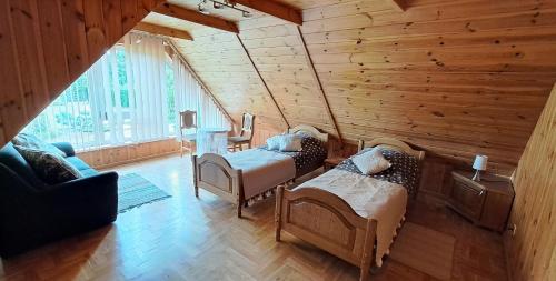 um quarto com 2 camas num quarto de madeira em Cottage - Liepų Sodyba em Joniškėlis