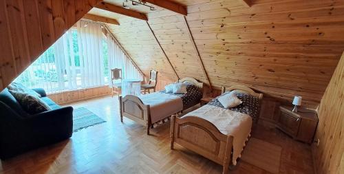 a room with two beds in a wooden room at Cottage - Liepų Sodyba in Joniškėlis