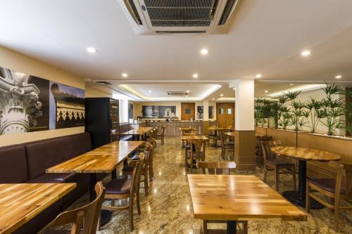 ein Restaurant mit Holztischen und -stühlen in der Unterkunft Gamboa Rio Hotel in Rio de Janeiro