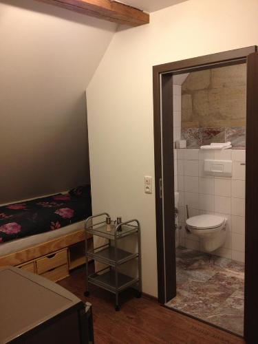 a bathroom with a toilet and a bed at Old Town Guesthouse Erlangen in Erlangen