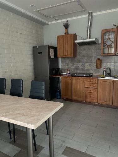 a kitchen with a table and chairs and a refrigerator at Будинок для відпочинку Dana in Berehove