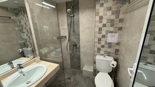 a bathroom with a shower and a toilet and a sink at Семеен хотел Сирена in Ahtopol