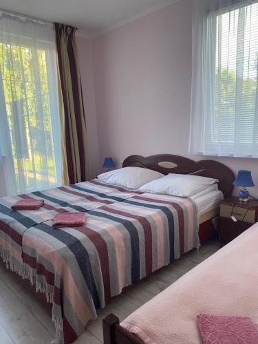 1 Schlafzimmer mit 2 Betten und einer gestreiften Decke in der Unterkunft Будинок для відпочинку Dana in Berehowe