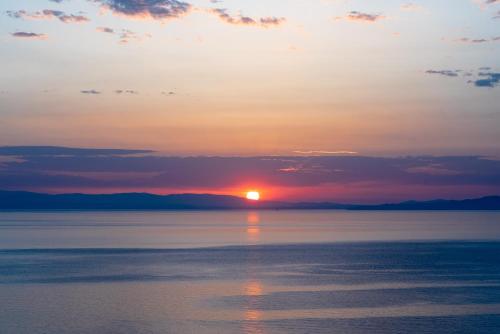 a sunset over a body of water at Apelon Tiritas Villas in Leonidion