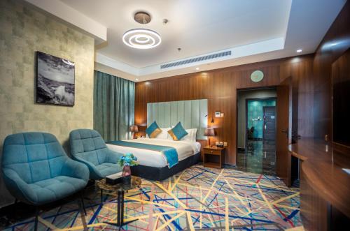 una camera d'albergo con un letto e due sedie di Donatello Jeddah Hotel a Gedda