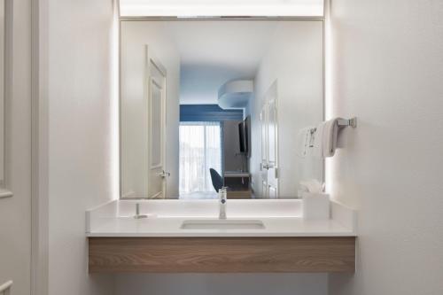 uma casa de banho com um lavatório branco e um espelho. em Courtyard by Marriott Sandestin at Grand Boulevard em Destin