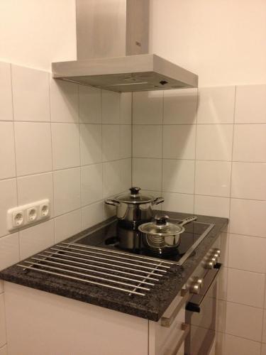 a kitchen with a stove with two pots on it at Old Town Guesthouse Erlangen in Erlangen