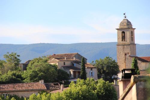 a building with a clock tower in a village at "Le Vent d'Étoile" B&B and Guesthouses in Mormoiron