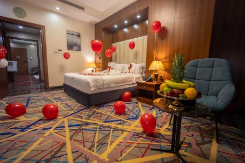 a room with a bed and a table with red balloons at Donatello Jeddah Hotel in Jeddah