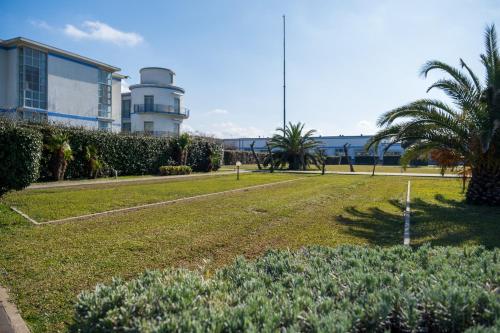 un parque con un edificio, palmeras y un edificio en Solidago Residence en Tirrenia
