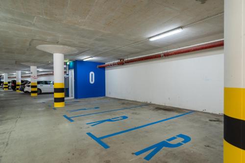 an empty parking garage with blue painted parking spaces at The Bridge City Luxury Apartments in Zadar