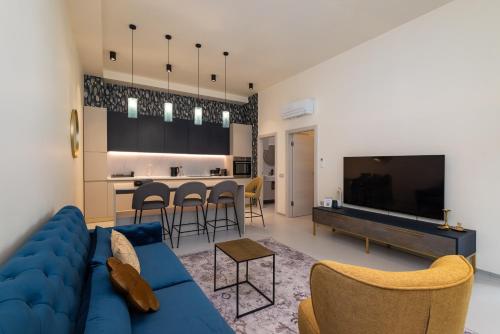 a living room with a blue couch and a kitchen at The Bridge City Luxury Apartments in Zadar