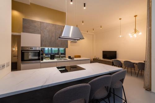 a kitchen with a large island in a kitchen with chairs at The Bridge City Luxury Apartments in Zadar