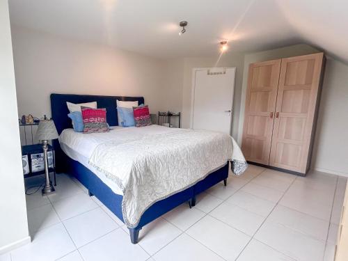 ein Schlafzimmer mit einem blauen und weißen Bett und einer Tür in der Unterkunft Tervuren in Tervuren