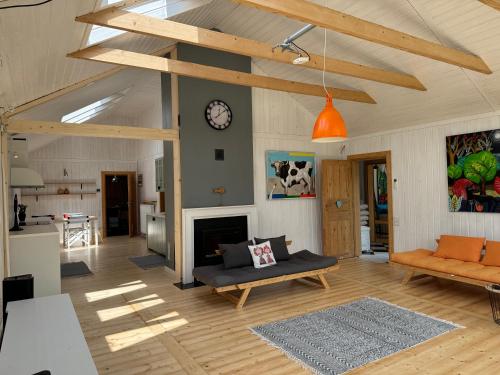 a living room with a couch and a clock on a wall at Dom w Starym Sadzie z basenem i sauną - Beskid Wyspowy in Nowe Rybie