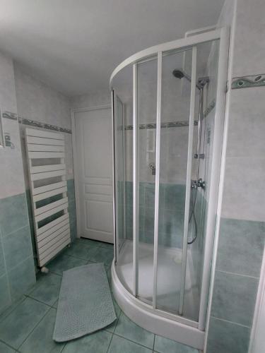 une douche avec une porte vitrée dans une salle de bain dans l'établissement GITE LA CÔTE de GRAVES, à Villefranche-de-Rouergue