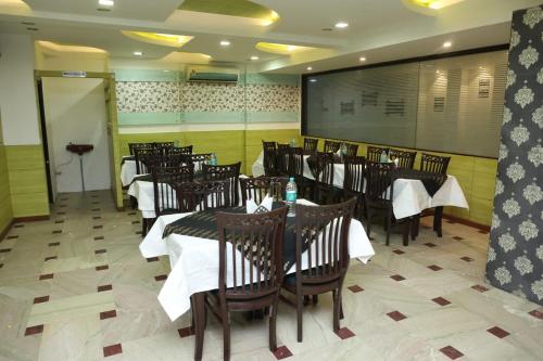 un comedor con mesas y sillas y una pizarra en Hotel Panna Paradise, en Agra