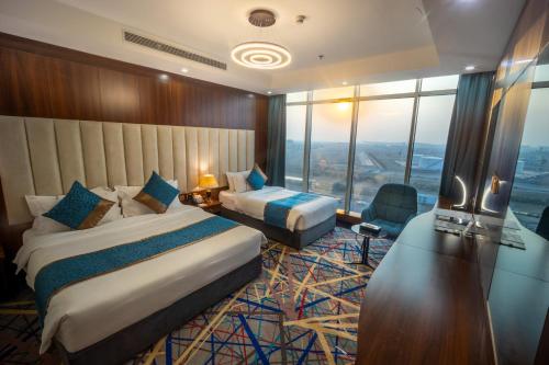 a hotel room with two beds and a large window at Donatello Jeddah Hotel in Jeddah