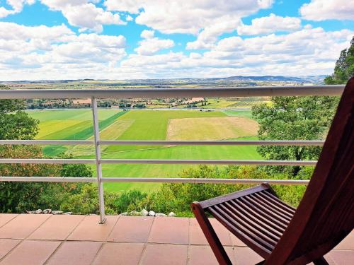 a chair sitting on a porch looking at a golf course at Hotel Rural & Spa Las Nubes in Albalate de Zorita