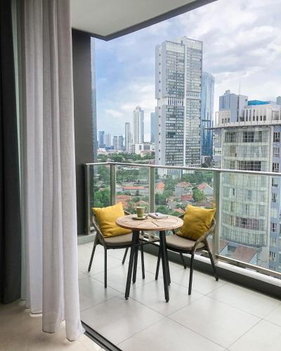 a table and chairs in a room with a large window at Mangkuluhur Residences by Lorin in Jakarta