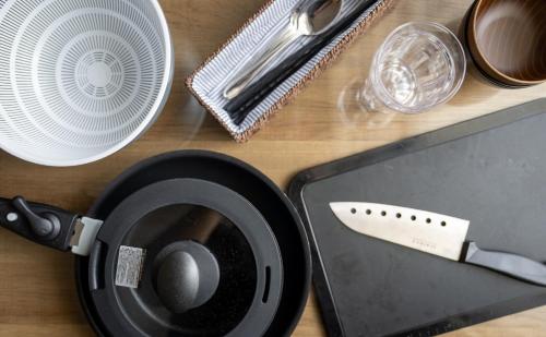 a table with a knife and plates and a laptop at Hotel SERA LUNA -ホテル セラルナ- in Naha