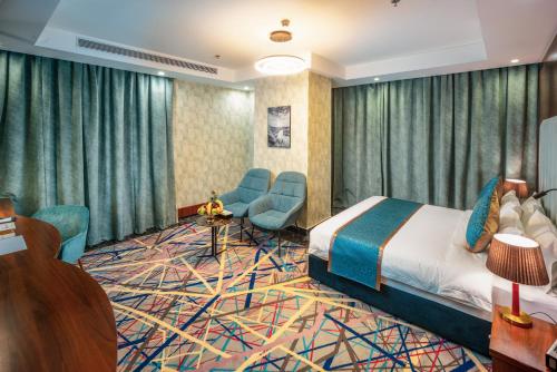 a hotel room with a bed and chairs at Donatello Jeddah Hotel in Jeddah
