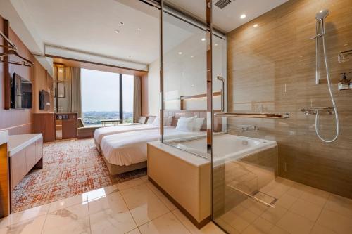 a bathroom with a bed and a shower and a sink at Candeo Hotels Osaka Hirakata in Hirakata