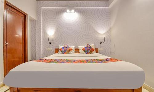 um quarto com uma grande cama branca com flores em FabHotel Shekhawati Palace em Jaipur
