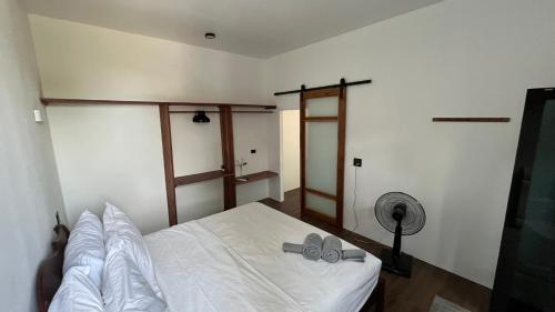 a bedroom with a white bed and a fan at Koh Tao studios in Koh Tao