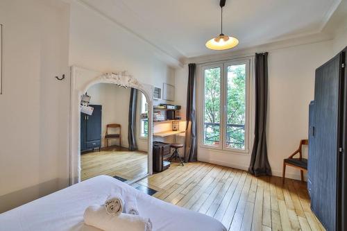 une chambre avec un lit, un miroir et un bureau dans l'établissement Appartement Parisien - Quartier Batignolles, à Paris