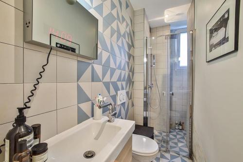 une salle de bain avec un lavabo et des toilettes dans l'établissement Appartement Parisien - Quartier Batignolles, à Paris