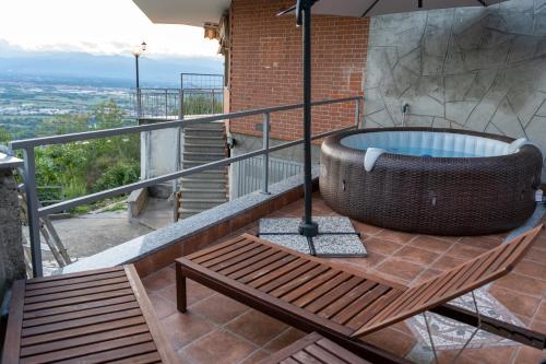 San Raffaele Cimena的住宿－Villa sulle nuvole，带浴缸和长凳的阳台